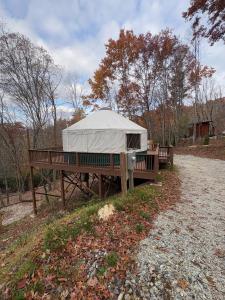 a white tent sitting on a table next to two benches at Pala Chino Yurt - Next to Nantahala Weddings in Aquone