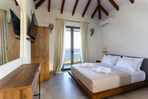 Giường trong phòng chung tại Eneos Boutique Residences - Koroni Poolside & Garden Retreats