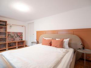 a bedroom with a bed with white sheets and orange pillows at Historisches Schiffmeisterhaus im Zentrum in Melk