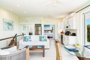ein Wohnzimmer mit einer weißen Couch und einem Tisch in der Unterkunft Wyakha 4 Ocean View in Long Bay Hills