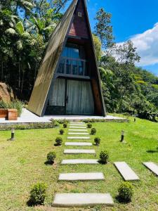 a stone path leading to a building in a field at Chalé Valentina-Luxo com Hidromassagem in Blumenau