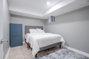 ein weißes Schlafzimmer mit einem Bett mit weißer Bettwäsche in der Unterkunft Renovated 2 Bedroom Basement Apartment Near 401 and Amenities in Bowmanville