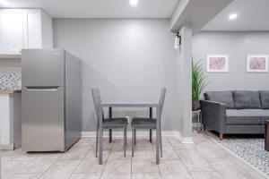 eine Küche mit Tisch und Stühlen und einer Couch in der Unterkunft Renovated 2 Bedroom Basement Apartment Near 401 and Amenities in Bowmanville + 6 Fotos