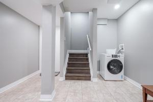 einen Flur mit einer Waschmaschine und einer Treppe in der Unterkunft Renovated 2 Bedroom Basement Apartment Near 401 and Amenities in Bowmanville