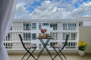 a balcony with a table and chairs in front of a building at Rose & Golf at Rose Apple Square in Siem Reap