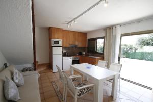 a kitchen with a white table and chairs at Casas Blancas 37 in Miami Platja