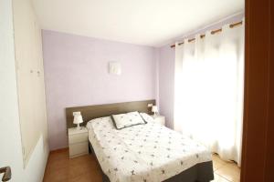 a small bedroom with a bed and a window at Casas Blancas 37 in Miami Platja +20 photos