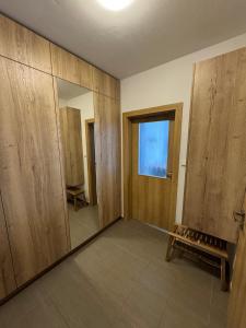 a room with wooden walls and a window and a mirror at Jedeme Lipno in Kobylnice