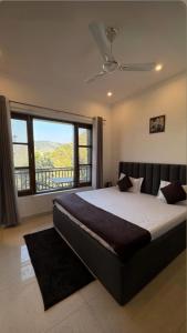una camera da letto con un letto grande e una grande finestra di Sarins Mistville 4BHK Villa Mall Road a Mussoorie