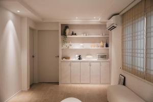 a living room with white cabinets and a window at 207stay korea in Busan +145 photos