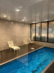 a swimming pool with two chairs and a table at Auckland CBD Apartment with Sky Tower View in Auckland