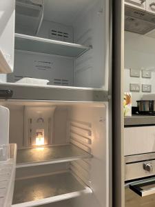 an empty refrigerator with its door open in a kitchen at Auckland CBD Apartment with Sky Tower View in Auckland +20 photos