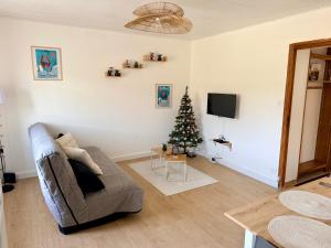 a living room with a christmas tree and a couch at Très bel appartement à 20 min de Gérardmer in Saulcy-sur-Meurthe