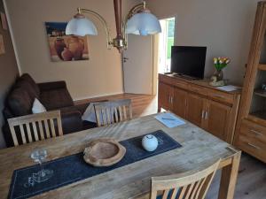 ein Wohnzimmer mit einem Holztisch und einem Esszimmer in der Unterkunft Ferienwohnung am Golfplatz in Adorf + 4 Fotos