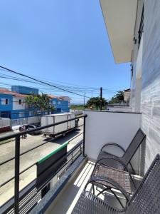 een balkon met twee stoelen en uitzicht op de oceaan bij studio 11 em Praia de Leste beach 1quarto in Pontal do Paraná