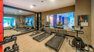 a fitness room with several treadmills and ellipticals at Serenis Hotel in Side