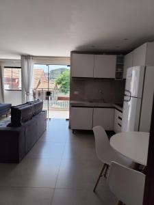 een keuken met een bank, een tafel en een koelkast bij studio 11 em Praia de Leste beach 1quarto in Pontal do Paraná