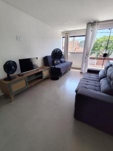 een woonkamer met een bank en een tv bij studio 11 em Praia de Leste beach 1quarto in Pontal do Paraná