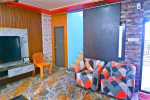 Una sala de estar con un sofá y un televisor. en MK sea view guest house, en Visakhapatnam