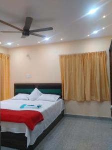 Un dormitorio con una cama y un ventilador de techo. en MK sea view guest house, en Visakhapatnam