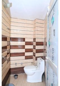 Shree Rajaram Homestay I Nearby Ram Mandir I Ayodhya في Ayodhya: حمام به مرحاض وجدار خشبي