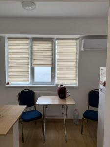 a kitchen with two windows and a table and chairs at DecoStudio in Craiova