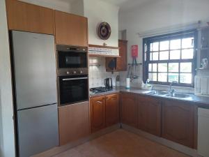 a kitchen with wooden cabinets and a white refrigerator at Alsouk in Vilamoura