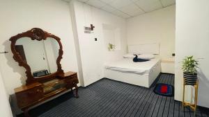 ウェリガマにあるWave Nest Hotelのベッドと鏡のある小さな部屋