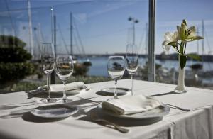 Una mesa con copas de vino y un jarrón con una flor. en Casa Becker, en Miami Platja