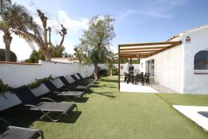 a row of chairs sitting on a lawn next to a building at Villa Atenea in Miami Platja