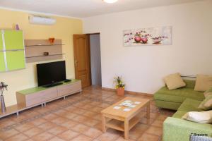 a living room with a couch and a television at Villa Atenea in Miami Platja