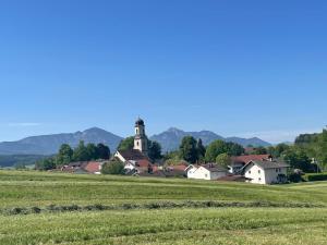a village with a church in the middle of a field at Haus am Obstanger in Traunstein