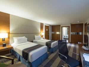 um quarto de hotel com duas camas e uma secretária em Lex Hotel Cebu em Cebu