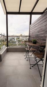 a balcony with a wooden bench and a table at Panorama Sunvilles Apartment 6 in Thessaloniki