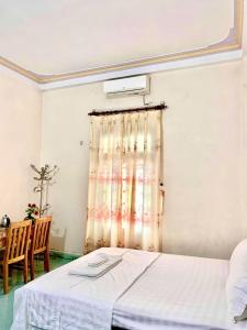 a bedroom with a bed with a curtain and a table at Khách sạn phong châu sốp cộp in Sơn La