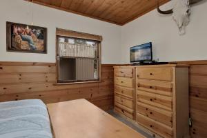 ein Schlafzimmer mit einem Bett und einem Fernseher auf einer Kommode in der Unterkunft Little bear #1079 in Big Bear Lake