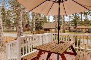 einem Picknicktisch aus Holz mit einem Schirm auf einem Zaun in der Unterkunft Little bear #1079 in Big Bear Lake