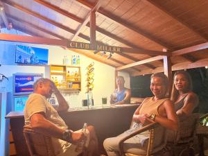 a group of people sitting in a bar at Kattegat Beachfront Villa in El Nido