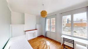 a white room with a table and a large window at Studio cozy in Le Havre