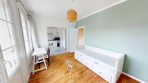 a bedroom with a white bed and a blue wall at Studio cozy in Le Havre