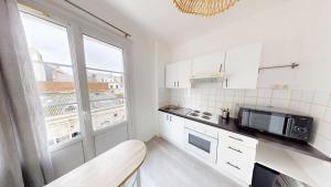 a small kitchen with a microwave and a window at Studio cozy in Le Havre +2 photos