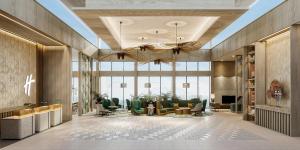 a lobby with a waiting area with chairs and a large window at Holiday Inn Lampung Bukit Randu by IHG in Bandar Lampung