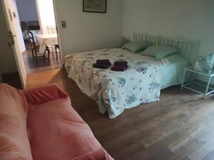 a bedroom with a bed and a couch in it at Au P'tit Venton - Maison Écologique in La Jaille-Yvon +3 photos