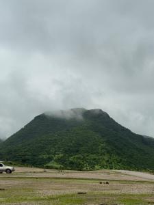 a car parked in front of a mountain at Evan Rest House in Salalah