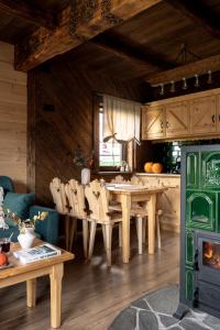 a living room with a table and a kitchen at Leśna Chatka in Dzianisz