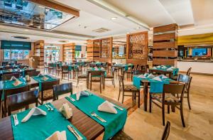 a restaurant with tables and chairs in a room at Serenis Hotel in Side