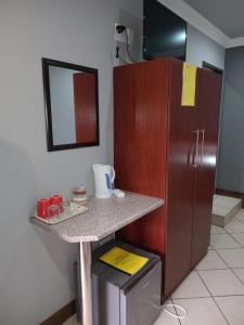 a kitchen with a counter and a refrigerator at Grand Central Guesthouse in Rustenburg