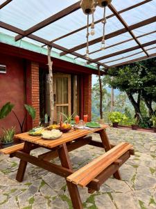 - une table de pique-nique sous une pergola sur une terrasse dans l'établissement The Palace Eco Cottage, à Ella