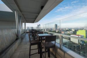 a balcony with tables and chairs and a view of the city at Lex Hotel Cebu in Cebu City