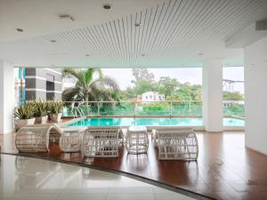 a living room with chairs and a swimming pool at Royal Beach View in Pattaya South